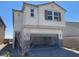 Two-story stucco home with a paved driveway leading to an open two-car garage and a desert-style landscaped yard at 9564 Hinson St, Las Vegas, NV 89102