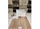 Close up of kitchen material samples, featuring white cabinets, quartz countertop, and wood-style flooring at 9564 Hinson St, Las Vegas, NV 89102