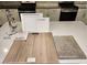 Close up of kitchen material samples, including white cabinets, quartz countertop, and driftwood flooring at 9564 Hinson St, Las Vegas, NV 89102