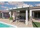Outdoor patio area with a covered seating area and a shed next to the clear water of the pool at , North Las Vegas, NV 89031