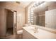 Bright bathroom with large vanity mirror and shower with glass doors at 10414 Midseason Mist St, Las Vegas, NV 89183