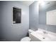 Cozy bathroom with blue tiled walls, a white vanity, and a framed mirror at 10414 Midseason Mist St, Las Vegas, NV 89183
