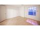 Sunny bedroom with light hardwood floors, a large window, and a white door at 10414 Midseason Mist St, Las Vegas, NV 89183