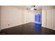 Bright room with dark wood floors features a ceiling fan and sliding doors to the exterior at 10414 Midseason Mist St, Las Vegas, NV 89183