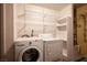 Functional laundry area with washer, dryer, and storage shelves at 10414 Midseason Mist St, Las Vegas, NV 89183
