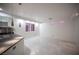 Bright living room featuring tile floors, modern lighting, and an adjacent kitchen area at 10414 Midseason Mist St, Las Vegas, NV 89183