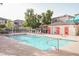 Community pool featuring lounge chairs and a restroom area with red doors at 10414 Midseason Mist St, Las Vegas, NV 89183