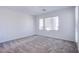 Bright bedroom features neutral carpet, two windows, and sliding door to patio at 145 Aqua Commons Ln, Henderson, NV 89015