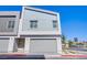 Modern two-story house with a gray facade, two-car garage, and minimalist landscaping in front at 145 Aqua Commons Ln, Henderson, NV 89015