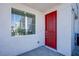 Charming front porch with a bright red door and a window to the left, creating a welcoming entrance at 145 Aqua Commons Ln, Henderson, NV 89015
