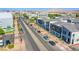 Modern townhomes line a street with landscaped sidewalks and mountain views in the distance at 145 Aqua Commons Ln, Henderson, NV 89015