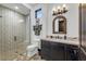 Bathroom showcasing walk-in shower, dark wood vanity, decorative mirror, and hexagonal tile flooring at 1616 Villa Rica Dr, Henderson, NV 89052