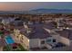 Aerial view of a home at sunset featuring pool, patio, and mountain views at 1616 Villa Rica Dr, Henderson, NV 89052