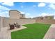 A well-maintained backyard featuring a manicured lawn and a cozy patio area with seating at 1631 Desert Path Ave, North Las Vegas, NV 89032