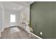 Inviting entryway with green accent wall, table, decor and white front door at 1631 Desert Path Ave, North Las Vegas, NV 89032