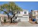 Charming two-story home features a well-manicured front yard and a classic stucco facade, creating a welcoming curb appeal at 1716 Klamath Falls Way, Las Vegas, NV 89128