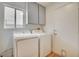 Well-lit laundry room featuring cabinets above new white washer and dryer at 1716 Klamath Falls Way, Las Vegas, NV 89128