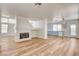 Open living room with a cozy fireplace, wood-look floors, and a seamless transition to the kitchen and backyard access at 1716 Klamath Falls Way, Las Vegas, NV 89128