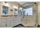 Bathroom featuring double sinks, granite counters, glass shower, and decorative tile work at 1779 Antelope Valley Ave, Henderson, NV 89012