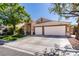 Tan home featuring a well-maintained lawn and a three-car garage at 1779 Antelope Valley Ave, Henderson, NV 89012