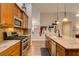 Modern kitchen with stainless steel appliances, tile backsplash, and wooden cabinetry at 1779 Antelope Valley Ave, Henderson, NV 89012