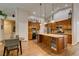 Well-lit kitchen with a spacious island, stainless steel appliances, wooden cabinets, and modern pendant lighting at 1779 Antelope Valley Ave, Henderson, NV 89012