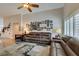 Spacious living room with hardwood floors, a large sofa, and an accent wall with a collection of photos at 1779 Antelope Valley Ave, Henderson, NV 89012