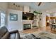 Cozy living room featuring a fireplace, hardwood floors, neutral decor, and an open layout to the kitchen at 1779 Antelope Valley Ave, Henderson, NV 89012