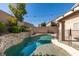 In-ground pool with fence and stone retaining wall and lighting at 1779 Antelope Valley Ave, Henderson, NV 89012