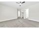 Neutral bedroom featuring plush gray carpet, ceiling fan and several doors at 2112 Hollow Oak Ave, North Las Vegas, NV 89031