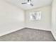 Bedroom features plush gray carpet, ceiling fan, and view to exterior at 2112 Hollow Oak Ave, North Las Vegas, NV 89031
