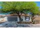 Inviting home featuring shade trees, a paved driveway, and an attached garage at 2112 Hollow Oak Ave, North Las Vegas, NV 89031
