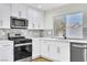 Updated kitchen with stainless steel appliances, subway tile backsplash, and white cabinets at 2112 Hollow Oak Ave, North Las Vegas, NV 89031
