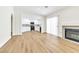 Bright living room features wood floors, a fireplace, and opens to a kitchen with gray backsplash at 2112 Hollow Oak Ave, North Las Vegas, NV 89031