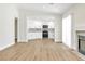 Bright living room boasts wood floors, modern fireplace, and open floorplan to the kitchen at 2112 Hollow Oak Ave, North Las Vegas, NV 89031