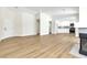 Bright open living area with wood-look flooring, and a fireplace adjacent to a doorway to the kitchen at 2112 Hollow Oak Ave, North Las Vegas, NV 89031