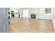 Open-concept living room featuring wood-look flooring, a fireplace and a renovated kitchen in the background at 2112 Hollow Oak Ave, North Las Vegas, NV 89031