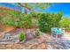 Beautiful backyard garden featuring lush landscaping, a charming bridge, and a cozy seating area at 2205 Sandstone Cliffs Dr, Henderson, NV 89044