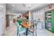 Open kitchen with island, wooden cabinets, tile flooring, and tropical-themed dining table and cabinet at 2205 Sandstone Cliffs Dr, Henderson, NV 89044
