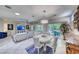 Bright living room featuring a white sectional sofa, dining set, and sliding door to the outdoor patio at 2205 Sandstone Cliffs Dr, Henderson, NV 89044