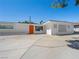Beautiful single-story home boasts a vibrant orange door, with a white exterior and manicured front yard at 2245 Sombrero Dr, Las Vegas, NV 89169