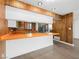 Spacious kitchen with bright orange countertops, wood paneling, and sleek stainless steel appliances at 2245 Sombrero Dr, Las Vegas, NV 89169