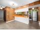 Well-lit kitchen with wood paneling, stainless steel appliances, breakfast bar, and green accents at 2245 Sombrero Dr, Las Vegas, NV 89169