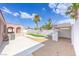 An inviting backyard showcases a covered patio, unique xeriscaping, synthetic grass, and privacy walls at 2403 Sexton Ave, North Las Vegas, NV 89031