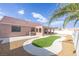 An inviting backyard showcases a covered patio, unique xeriscaping, synthetic grass, and privacy walls at 2403 Sexton Ave, North Las Vegas, NV 89031
