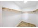 A walk-in closet features fresh paint, wood-look flooring, and ample shelf space with wooden closet rods at 2403 Sexton Ave, North Las Vegas, NV 89031