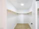 A walk-in closet features fresh paint, wood-look flooring, and ample shelf space with wooden closet rods at 2403 Sexton Ave, North Las Vegas, NV 89031