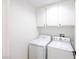 The laundry room features a white washer and dryer with white cabinets above at 2403 Sexton Ave, North Las Vegas, NV 89031