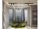 Contemporary bathroom showcasing a standalone green bathtub and large window with blinds at 2935 Montessouri St, Las Vegas, NV 89117