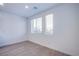 Bright bedroom features wood-look floors, white walls and trim, and dual windows at 31 Newport Edge Pl, Henderson, NV 89015